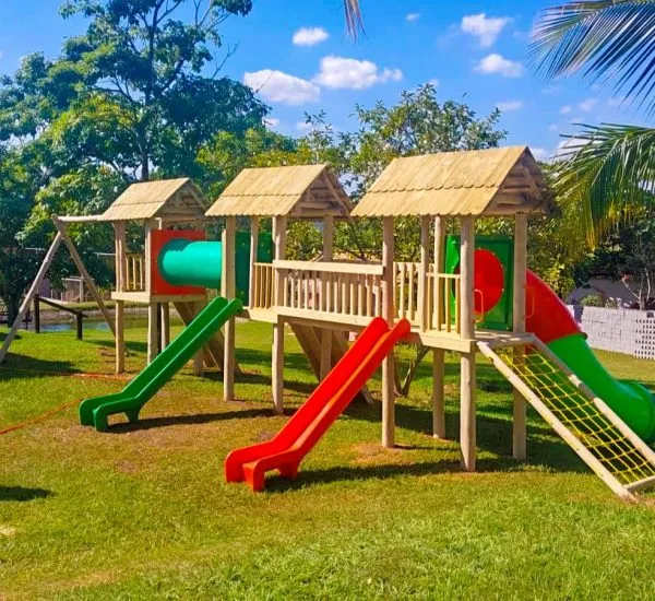 Playground de madeira tratada com escorregador e torre de escalada