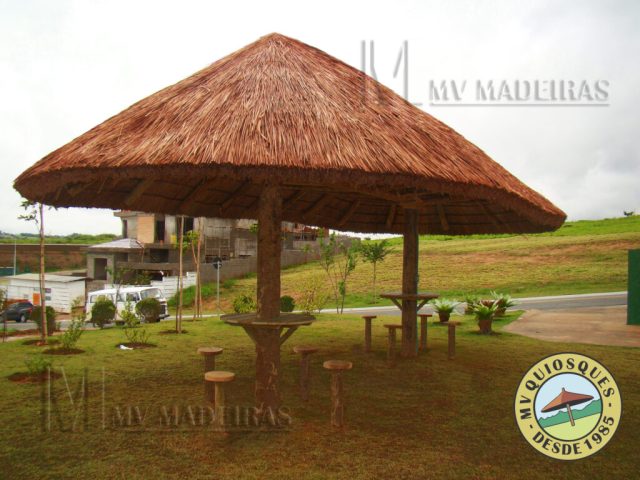 Quiosque de sapê com mesa e banquetas para área de lazer do condomínio