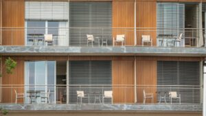 Um Edificio Alto Com Varandas E Cadeiras Nas Varandas 1PdHMTELbxE